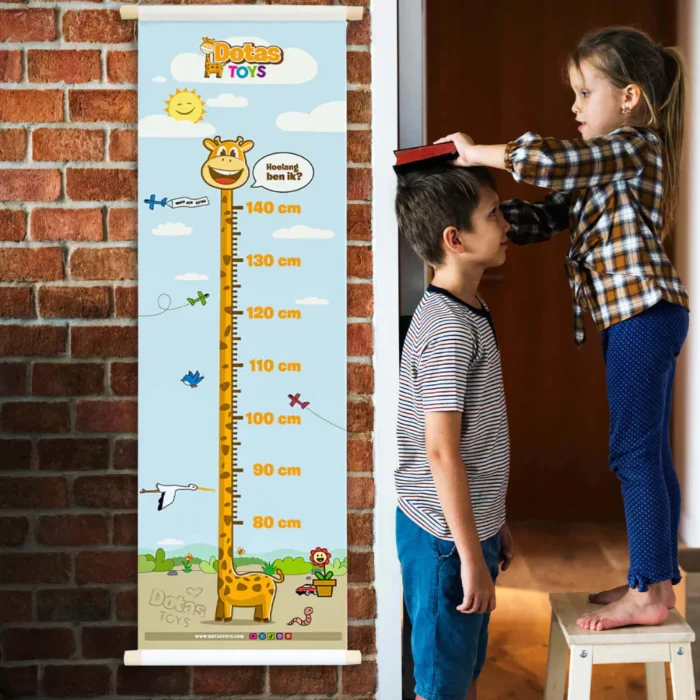 Kinderen meten samen lengte met DotasToys Groeimeter aan bakstenen muur, meisje op krukje meet broertje met boek op hoofd, interactief spelen en leren